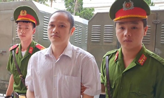 Cảnh sát dẫn giải ông Lương vào phòng xử án sáng này 14.10. Ảnh: H. Tâm.