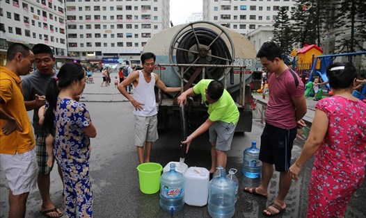 Những ngày qua, trước hiện tượng nước "có mùi lạ", dân cư ở nhiều khu chung cư đã phải đi xin nước về sử dụng. Ảnh: Sơn Tùng