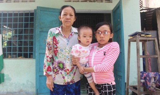 Bà Trần Thị Lài và hai mẹ con chị Láng trước căn nhà tình thương đã xuống cấp, hư hỏng.