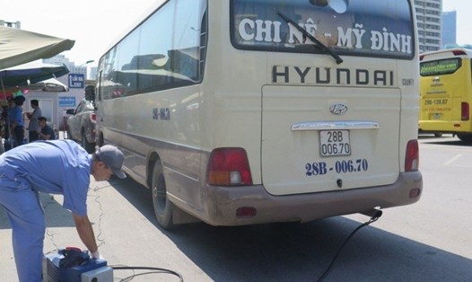 Đăng kiểm viên kiểm tra đột xuất chất lượng khí thải một xe khách chạy tuyến cố định tại Bến xe Mỹ Đình (Hà Nội). Ảnh: PV