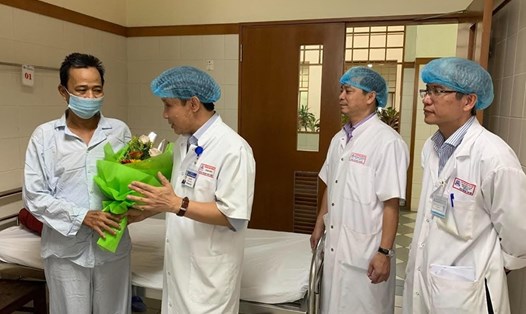 GS.TS Phạm Như Hiệp - Giám đốc Bệnh viện Trung ương Huế (phải), tặng hoa và căn dặn bệnh nhân Tý trước khi ra viện.