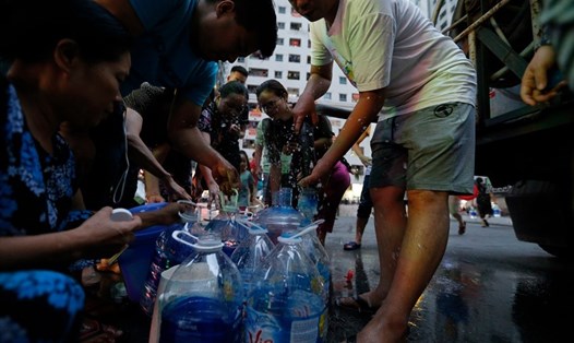 Dân Hà Nội xuyên đêm xếp hàng lấy nước sạch sau vụ nước sông Đà nhiễm dầu. Ảnh: Sơn Tùng, Tô Thế