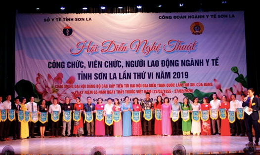 Ban tổ chức tặng cờ lưu niệm cho 29 đoàn nghệ thuật quần chúng đến từ 34 công đoàn cơ sở trong ngành Y tế Sơn La. Ảnh: L.Chuyển