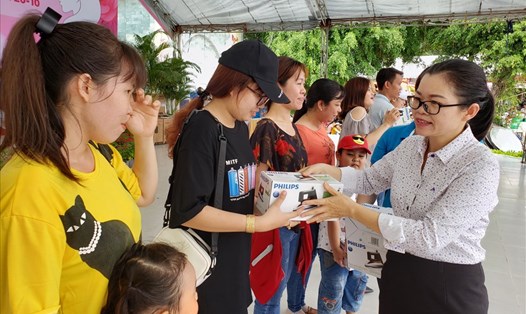 Chủ tịch Công đoàn khu công nghiệp Biên Hòa Nguyễn Thị Tuyết (góc phải) tặng phần thưởng bốc thăm may mắn cho người lao động. Ảnh: HAC