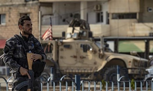 Một chiến binh của Lực lượng Dân chủ Syria (SDF) nhìn xe quân sự Mỹ rút khỏi miền bắc Syria. Ảnh: AFP/Getty Images
