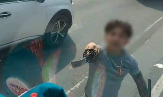 Người thanh niên rút kiếm Nhật chém vào cửa kính xe tải - Ảnh cắt từ video.