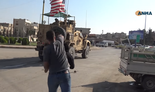 Xe quân sự Mỹ rời khỏi Syria bị người Kurd ném đá và cà chua. Ảnh chụp màn hình clip của Hewar News