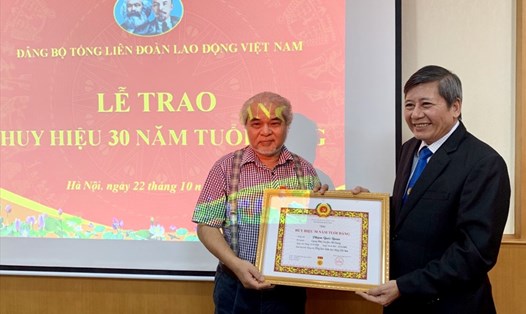 Đồng chí Trần Thanh Hải - Phó Chủ tịch Thường trực Tổng LĐLĐVN (bên phải) trao Huy hiệu 30 năm tuổi Đảng cho đồng chí Phạm Quốc Quân. Ảnh: N.H