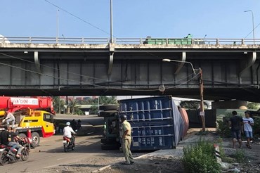 Xe container đụng vào gầm cầu lật nhào giữa đường rất may không gây tai nạn cho người dân.