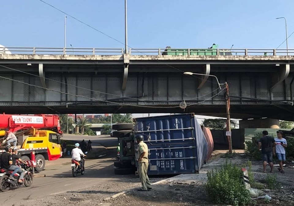 Xe container đụng vào gầm cầu lật nhào giữa đường rất may không gây tai nạn cho người dân.
