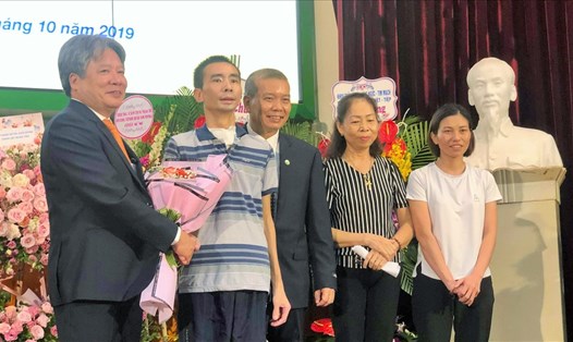 Giám đốc Bệnh viện Việt Đức tặng hoa chúc mừng bệnh nhân và gia đình. Ảnh: T.L