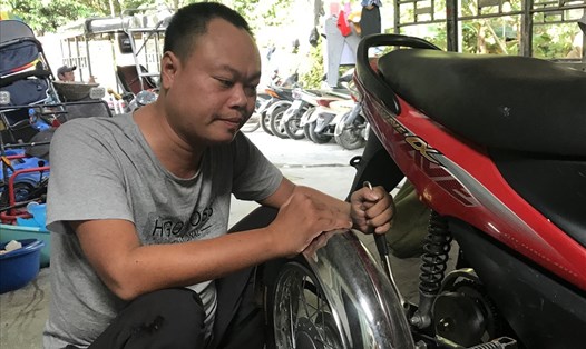 Anh Nguyễn Kim Cương chế tạo xe ba bánh dành cho người khuyết tật. Ảnh: PV