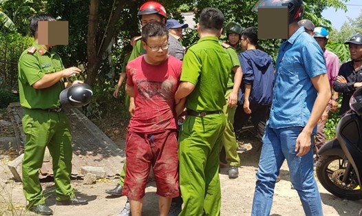 Đối tượng Lực (áo đỏ) bị lực lượng công an bắt giữ khi trốn ở căn nhà hoang cách hiện trường 500m. ảnh: H.V
