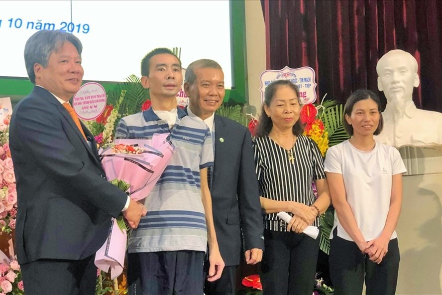 Giám đốc Bệnh viện Việt Đức tặng hoa chúc mừng bệnh nhân và gia đình. Ảnh: T.L