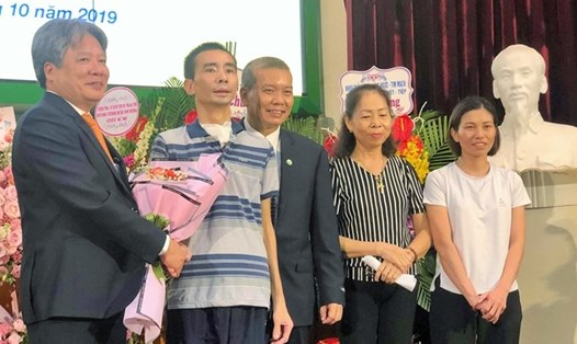 Giám đốc Bệnh viện Việt Đức tặng hoa chúc mừng bệnh nhân và gia đình. Ảnh: T.L
