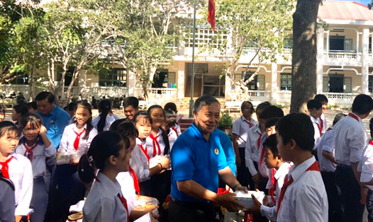 Đồng chí Trần Văn Dũng, Phó Chủ tịch Thường trực LĐLĐ tỉnh trao vở cho học sinh_Ảnh: LĐLĐ Bình Thuận