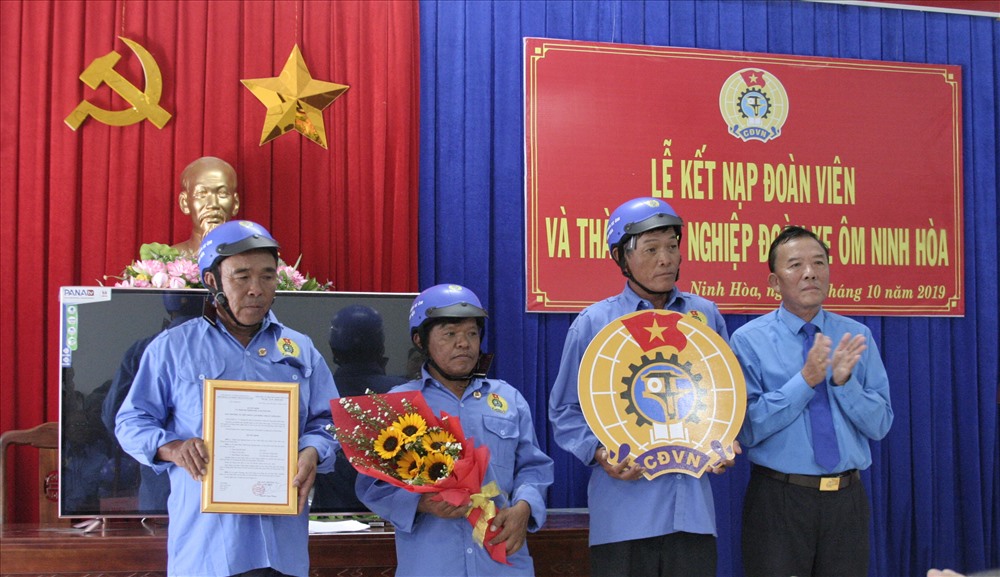 Lãnh đạo LĐLĐ Thị xã trao quyết định và logo công đoàn cho ban chấp hành lâm thời nghiệp đoàn xe ôm Ninh Hòa. Ảnh: Phương Linh