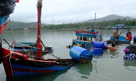 Người dân thị xã Sông Cầu (Phú Yên) đánh vật với các con tàu bị đắm chìm do bão số 5. Ảnh: V.H