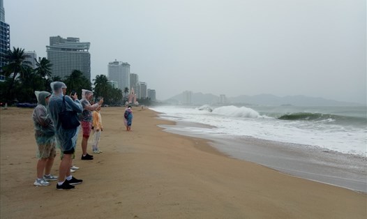 Nhiều du khách chiều 10.11 đội mưa gió đi dạo chụp hình sóng lớn trên biển Nha Trang. Ảnh:P.L