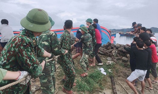 Bộ đội biên phòng giúp dân kéo tàu thuyền vào bờ tránh bão tại huyện Sông Cầu, tỉnh Phú Yên chiều 10.11. Ảnh: Đ.TH