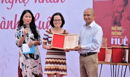 Tiến sĩ Nguyễn Mạnh Hùng - đại diện Thái Hà Books (bên phải, ảnh) trao ấn bản đặc biệt cho đại diện bạn đọc tham gia phiên đấu giá thành công ở Hà Nội . Ảnh: L.Q.V