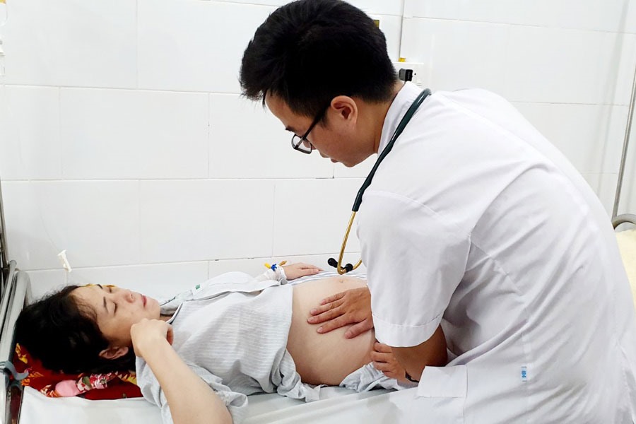 Bác sĩ khám cho một thai phụ mắc sốt xuất huyết. Ảnh: BSCC