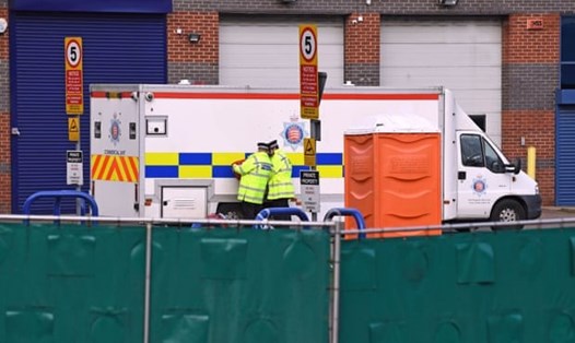 Cảnh sát hộ tống khi 39 thi thể được đưa lên xe cứu thương chuyển khỏi hiện trường tới bệnh viện Broomfield ở Chelmsford hồi tuần trước. Ảnh: PA.