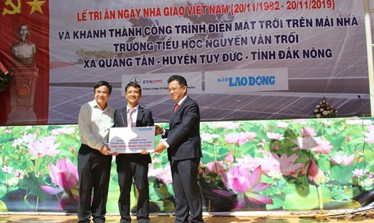 Đại diện Báo Lao Động và Tổng Cty Điện lực miền Trung trao tặng bảng tượng trưng cho công trình năng lượng mặt trời áp mái. Ảnh: HL