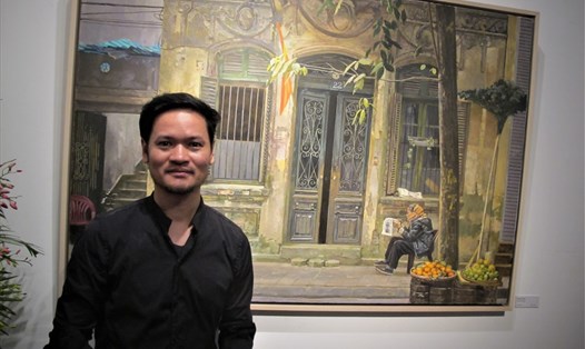 Họa sĩ Phạm Bình Chương bên một tác phẩm trong triển lãm ''Xuống phố 3'' tại Bảo tàng Mỹ thuật Việt Nam. Ảnh: L.Q.V