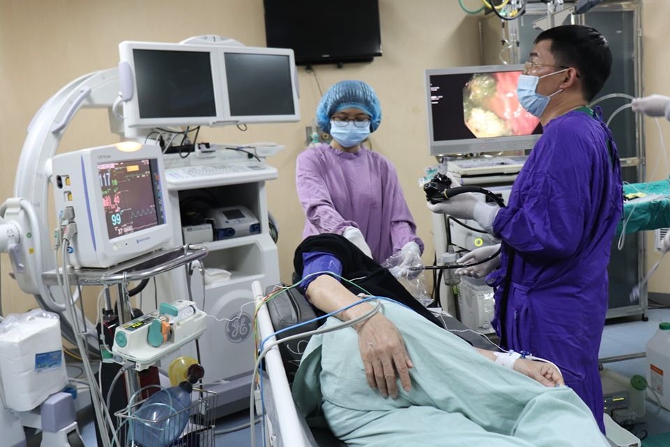 Các bác sĩ thực hiện gắp 2 khối bã thức ăn cho người bệnh.