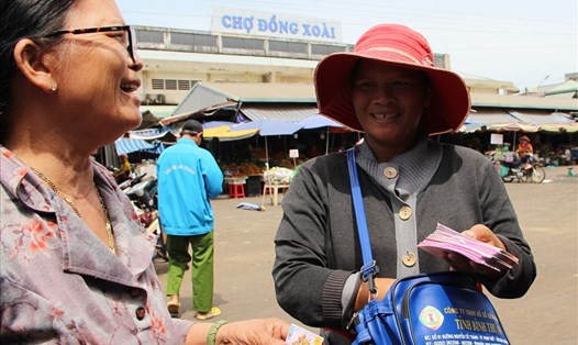 Chị Lê Thị Mai (phải) - người bán vé số ở chợ Đồng Xoài - trả lại 150 triệu đồng cho người đánh rơi. Ảnh: ĐT