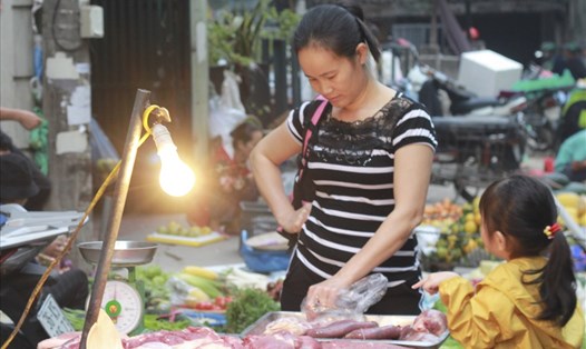 Người tiêu dùng chọn mua thịt lợn tại chợ dân sinh.