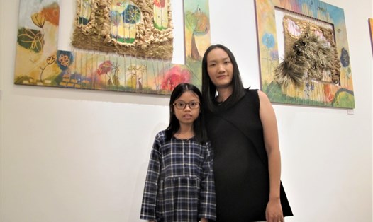 Nghệ sĩ Nguyễn Thùy Trang và ''họa sĩ nhí" Lê Thu Hà Bình bên tác phẩm sáng tác chung của hai cô - trò. Ảnh: L.Q.V