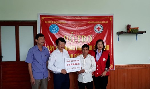 Các đồng chí lãnh đạo Bảo hiểm xã hội tỉnh, Hội Chữ thập đỏ tỉnh trao hỗ trợ cho gia đình anh Hậu.