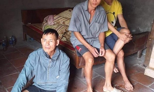 Ông Nguyễn Xuân Núi (ngồi dưới đất) cùng 2 người con trai bị bệnh tâm thần do di chứng chất độc da cam. Ảnh: Minh Tiến