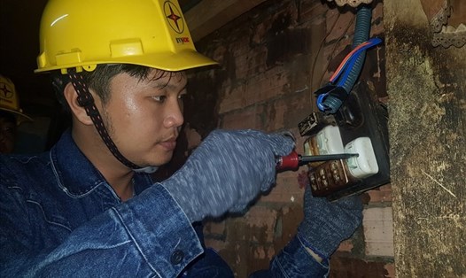 Công nhân EVNHCMC sửa hệ thống điện nhà của một hộ dân có hoàn cảnh khó khăn ở Quận 11. Ảnh Nam Dương