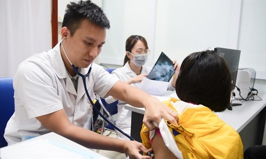 Bác sĩ khám cho bệnh nhi có biểu hiện cúm tại Bệnh viện Thanh Nhàn (Hà Nội). Ảnh: Duy Hiệu