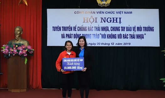 Vận động viên điền kinh Phạm Thị Hồng Lệ (trái) nhận phần thưởng từ Công đoàn Viên chức Việt Nam.