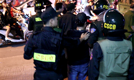 Cảnh sát cơ động đang dẫn giải một đối tượng tại hiện trường vụ việc tối ngày 21.12_Ảnh: CTV