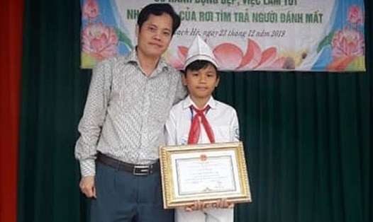 Phó Chủ tịch UBND huyện Thạch Hà Nguyễn Quốc Hương trao giấy khen cho em Duy. Ảnh: TT