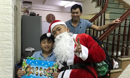 Một bé trai nhận vô cùng vui sướng khi được Ông Già Noel đến nhà tặng quà Noel. Ảnh: Mai Hương