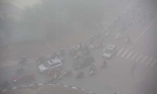 Sáng nay 24.12, người dân Hà Nội ra đường đi làm khi sương dày đặc phủ kín. Ảnh: Sơn Tùng.