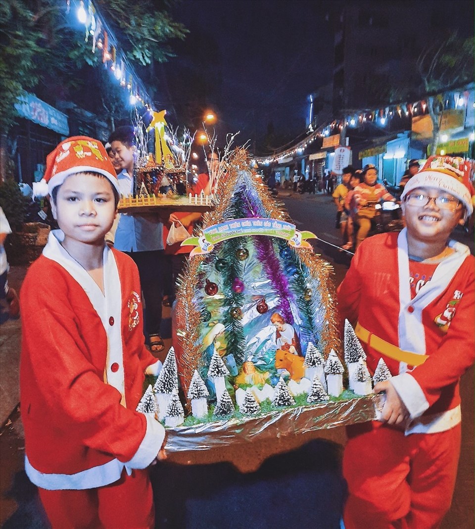 Hai em bé mặc đồ ông già Noel rước lễ vật ở khu xóm đạo, quận 8 (Ảnh: Phạm Thế Hiển)