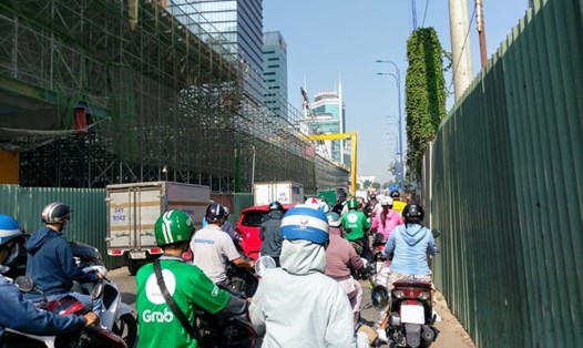 Người dân chen chúc trên đường Tôn Đức Thắng (quận 1) do lô cốt công trình cầu Thủ Thiêm 2 chiếm gần hết diện tích lòng đường.  Ảnh: M.Q