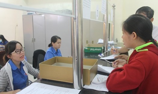 Cán bộ Bảo hiểm xã hội tỉnh Khánh Hoà hướng dẫn người dân hoàn thiện hồ sơ bảo hiểm y tế. Ảnh: Nhiệt Băng