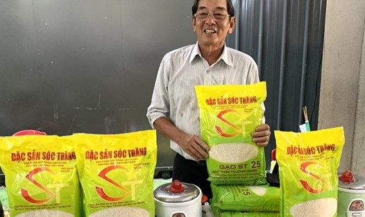 Anh hùng Lao động Hồ Quang Cua bên sản phẩm gạo ST25. Ảnh: NN