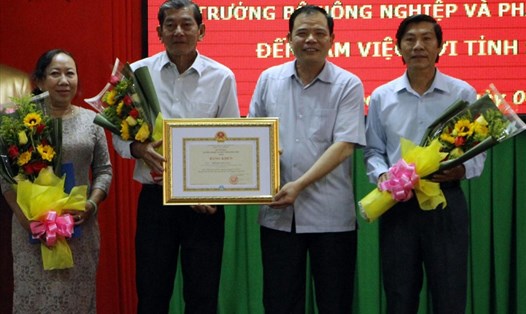 Bộ trưởng Bộ NNPTNT Nguyễn Xuân Cường tặng bằng khen cho nhóm tác giả đoạt giải gạo ngon nhất thế giới (ảnh Nhật Hồ)