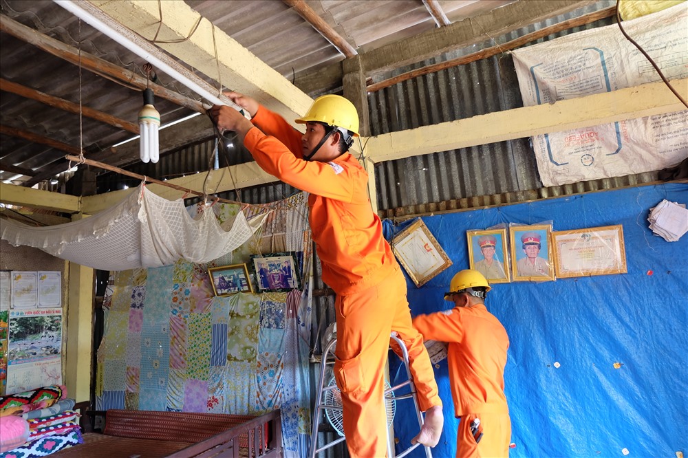 Nhân viên của EVNSPC thay mới bóng đèn cho các gia đình chính sách.