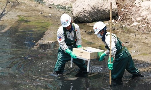 Công nhân lắp tấm Bioreactor xuống khu vực thí điểm làm sạch một đoạn sông Tô Lịch. Ảnh: PV