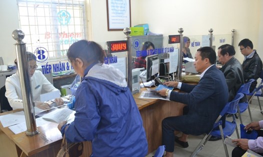 Bộ phận một cửa thuộc BHXH quận Thanh Xuân (Hà Nội) hướng dẫn người tham gia BHXH hoàn tất hồ sơ. Ảnh: H.A